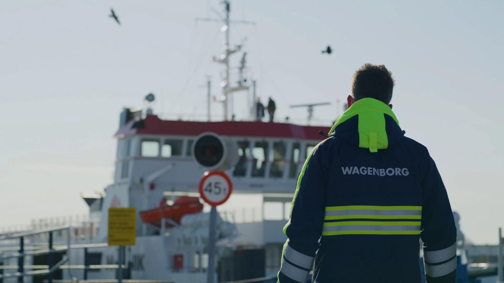 Wagenborg-medewerker in werkjas met reflectie op de kade bij de veerboot