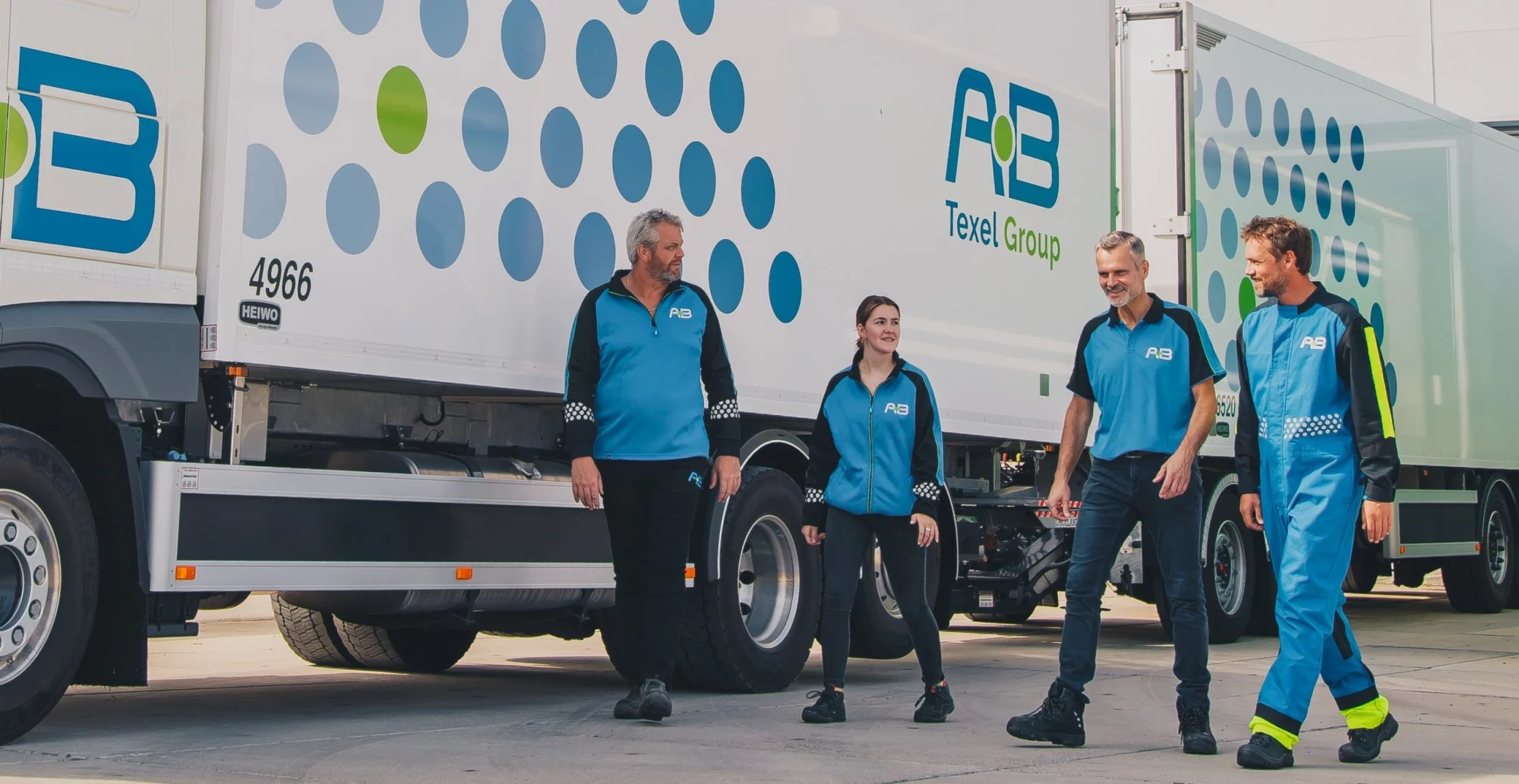 Medewerkers van AB Texel in blauwe bedrijfskleding bij hun truck