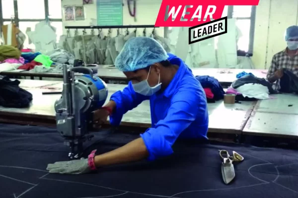 Medewerker aan de snijtafel in onze fabriek met het Fair Wear Leader-label