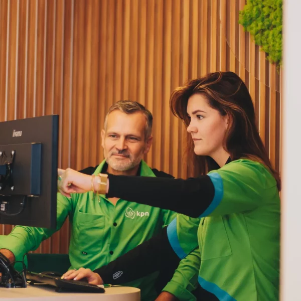 KPN-medewerkers in groene bedrijfskleding in de winkel