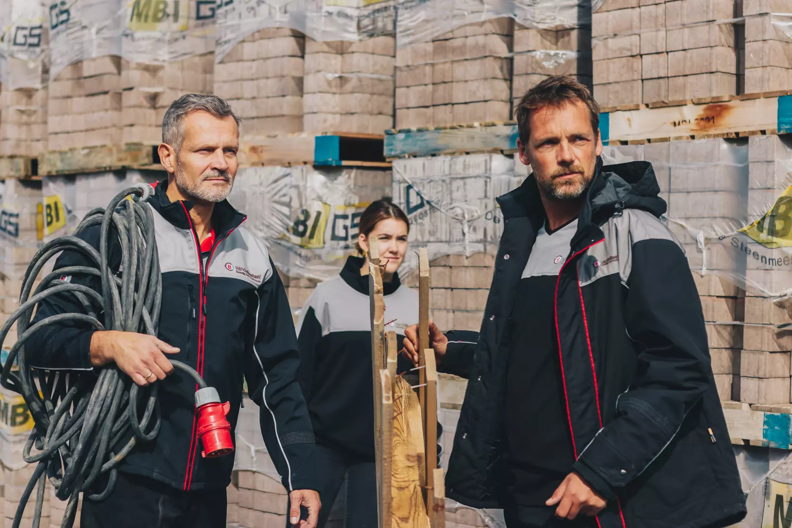 Medewerkers van De Romein in werkkleding met kabels en pallets