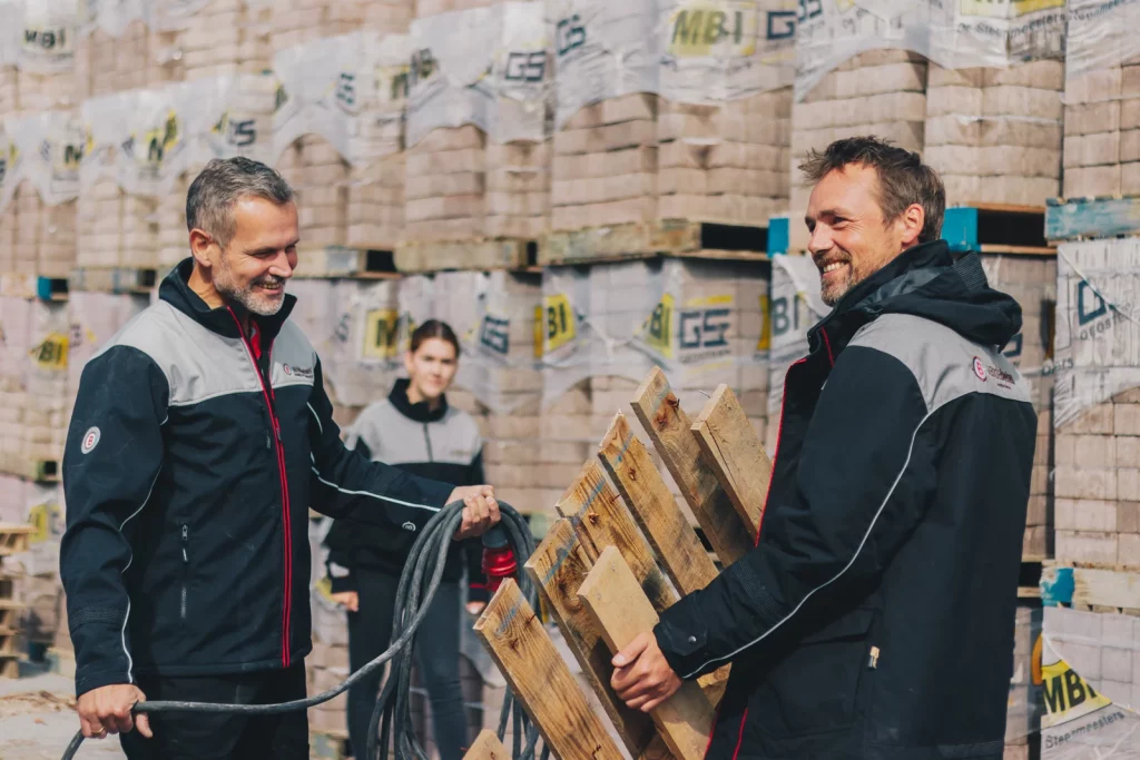 Medewerkers van De Romein in werkkleding bij de pallets