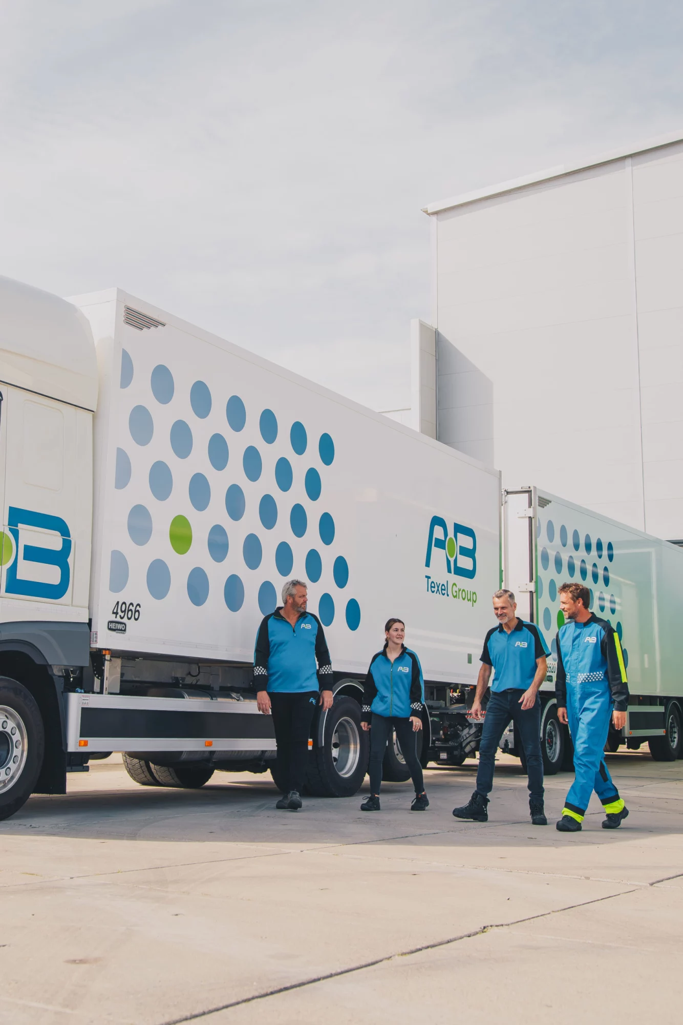 Chauffeurs van AB Texel in bedrijfskleding bij hun trucks