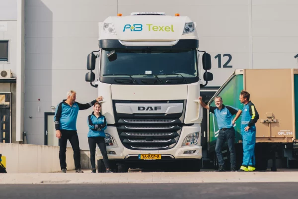 Team van AB Texel in bedrijfskleding voor een DAF-truck