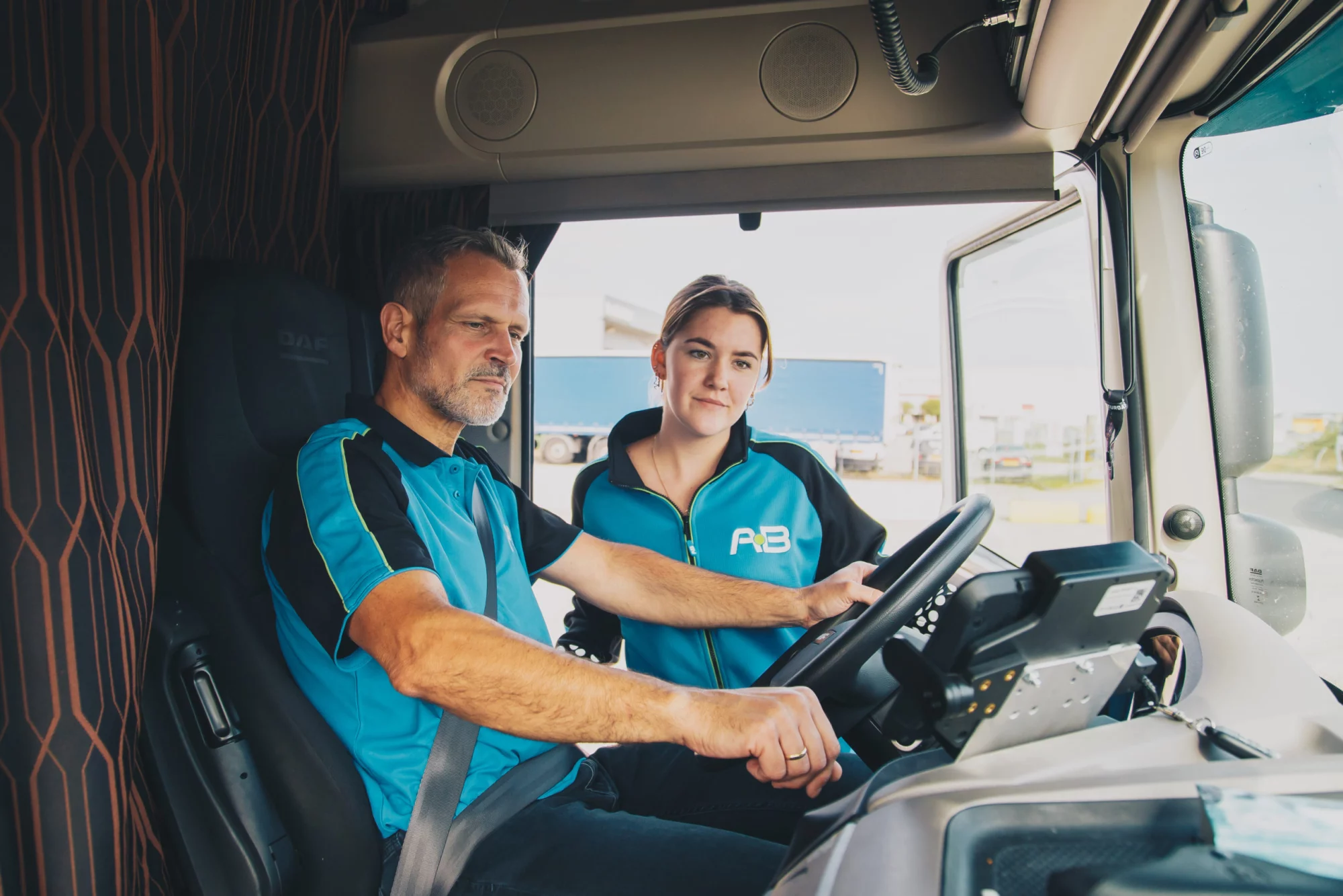 Chauffeurs van AB Texel in bedrijfskleding in de cabine