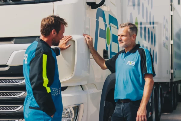 Twee medewerkers van AB Texel bij de cabine van een truck