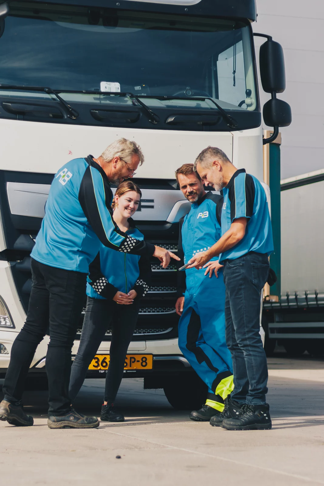 Medewerkster van AB Texel in bedrijfskleding bij de cabine van een truck