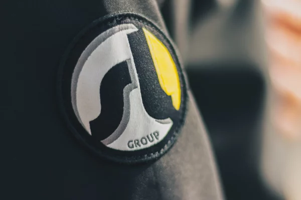 Geborduurd logo-embleem op de mouw van een donkere werkjas