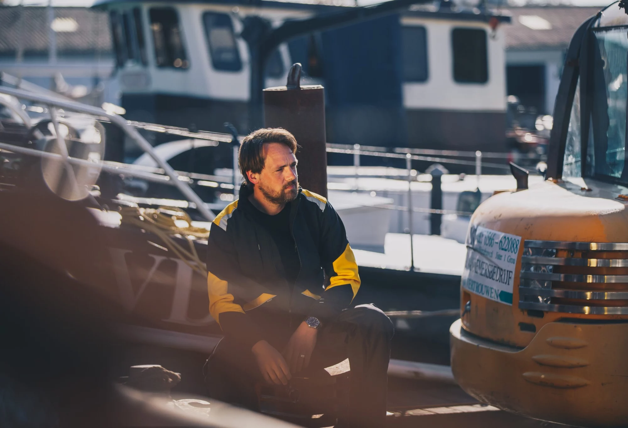 Man in Thirtyfour-jas op een boot in de haven