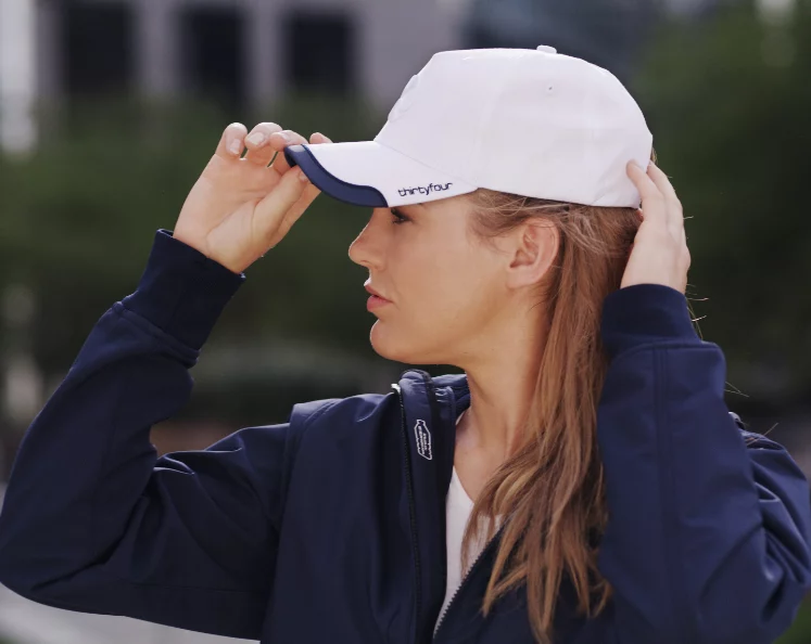 Vrouw zet een witte cap met logo op