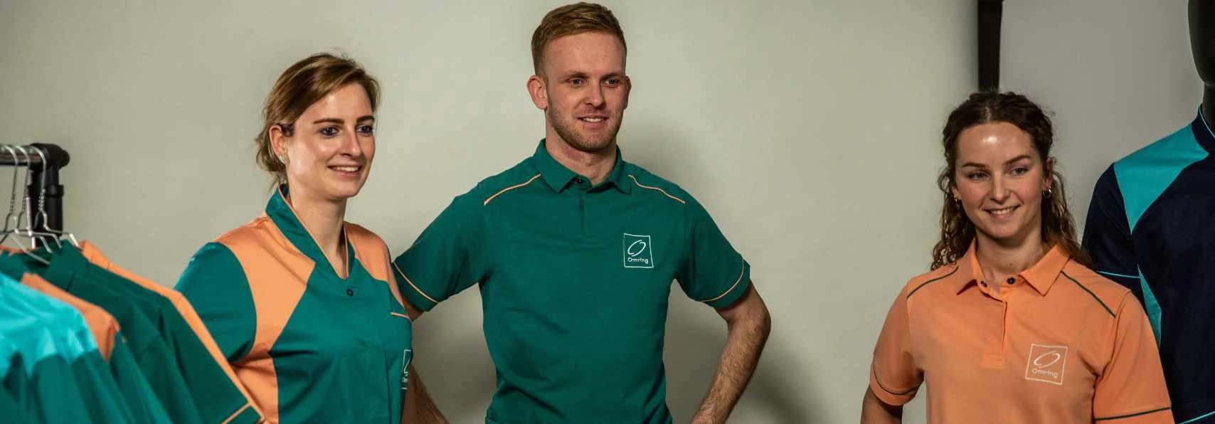 Zorgmedewerkers in groene en oranje polo's met huisstijl