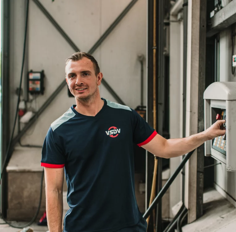 Medewerker in een donkerblauw polo met logo bij een meterkast