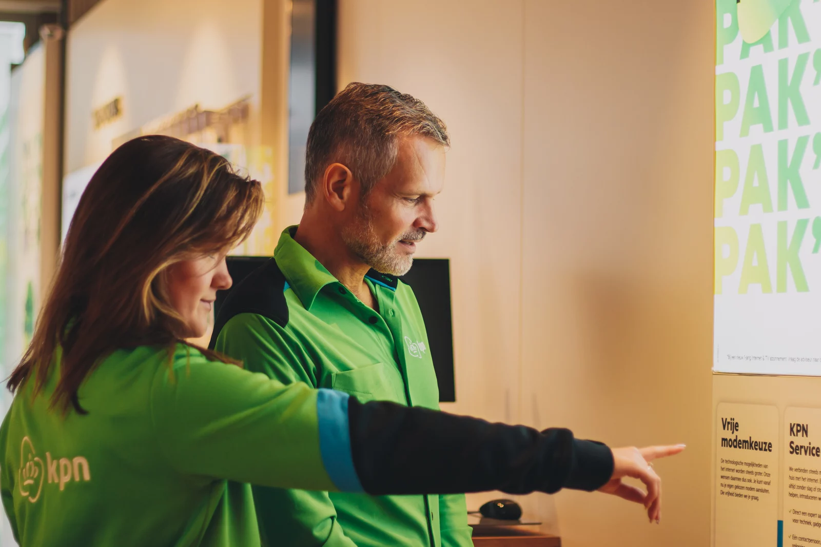 KPN-medewerkers in groene werkkleding bij een presentatie