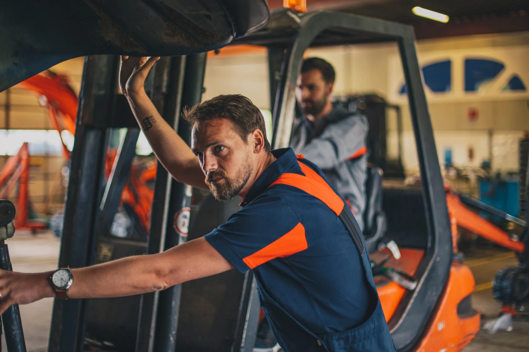 Medewerker in werkkleding aan het werk bij een heftruck