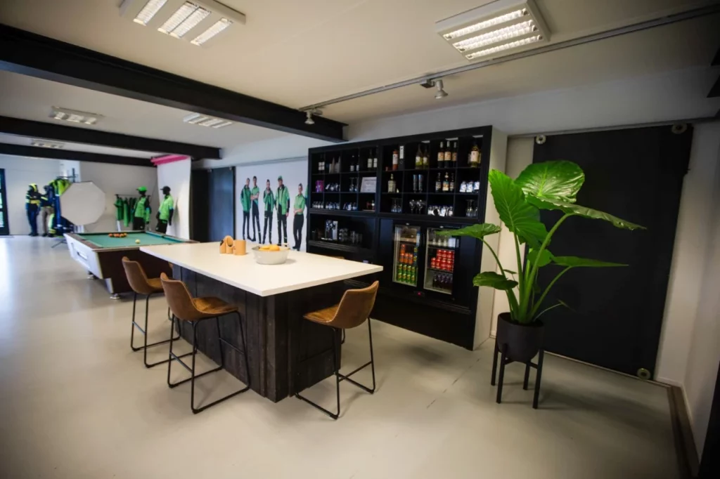Lounge met bar en planten in de showroom van Tailor & Stitch