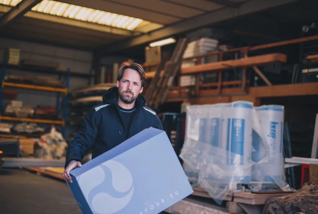 Man in Thirtyfour-jas met dozen in een werkplaats