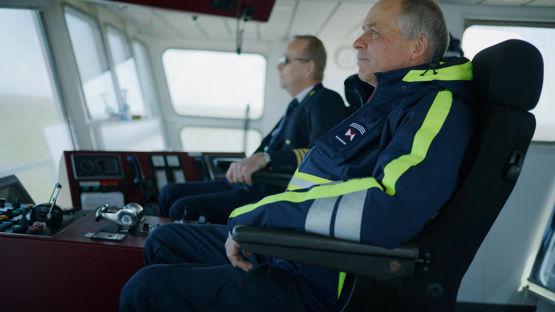 Wagenborg-medewerkers in werkkleding op de brug van de veerboot