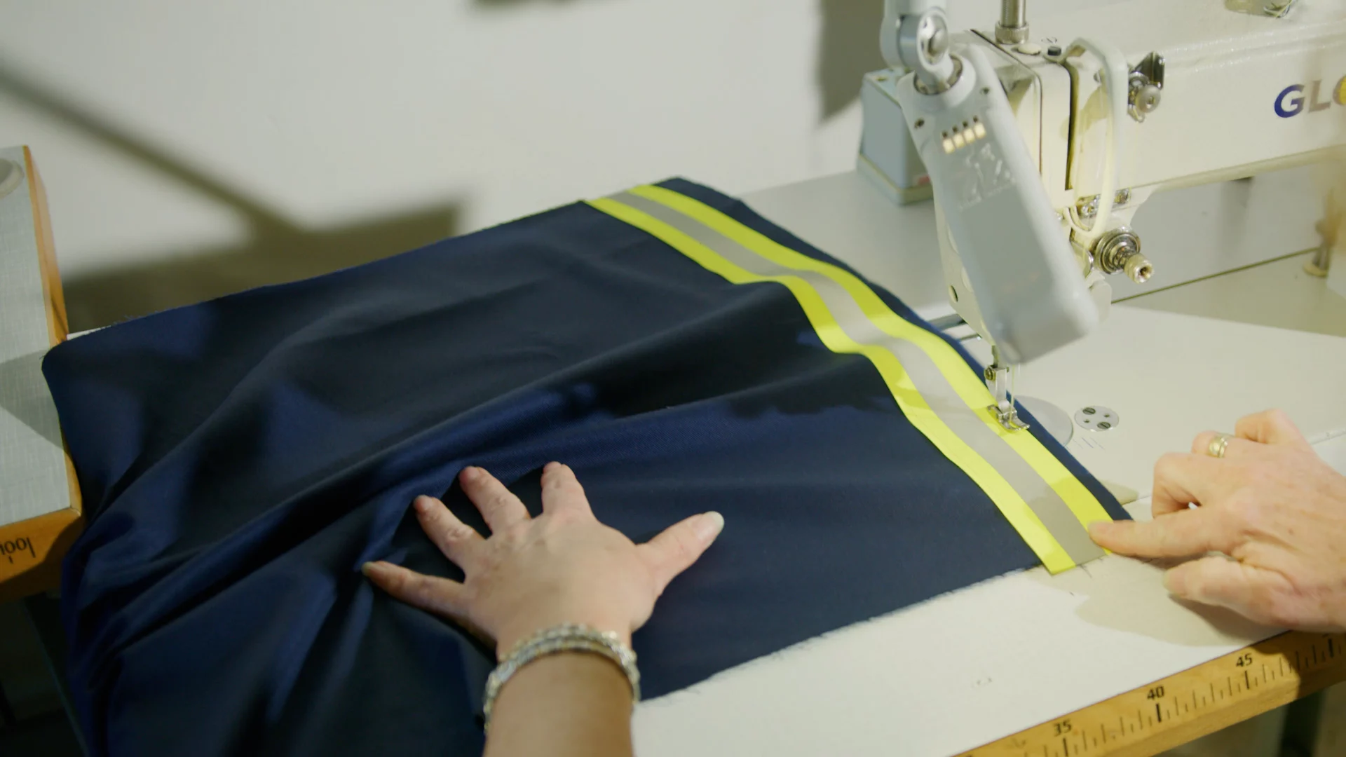 Werkjas van Wagenborg met reflecterende band onder de naaimachine
